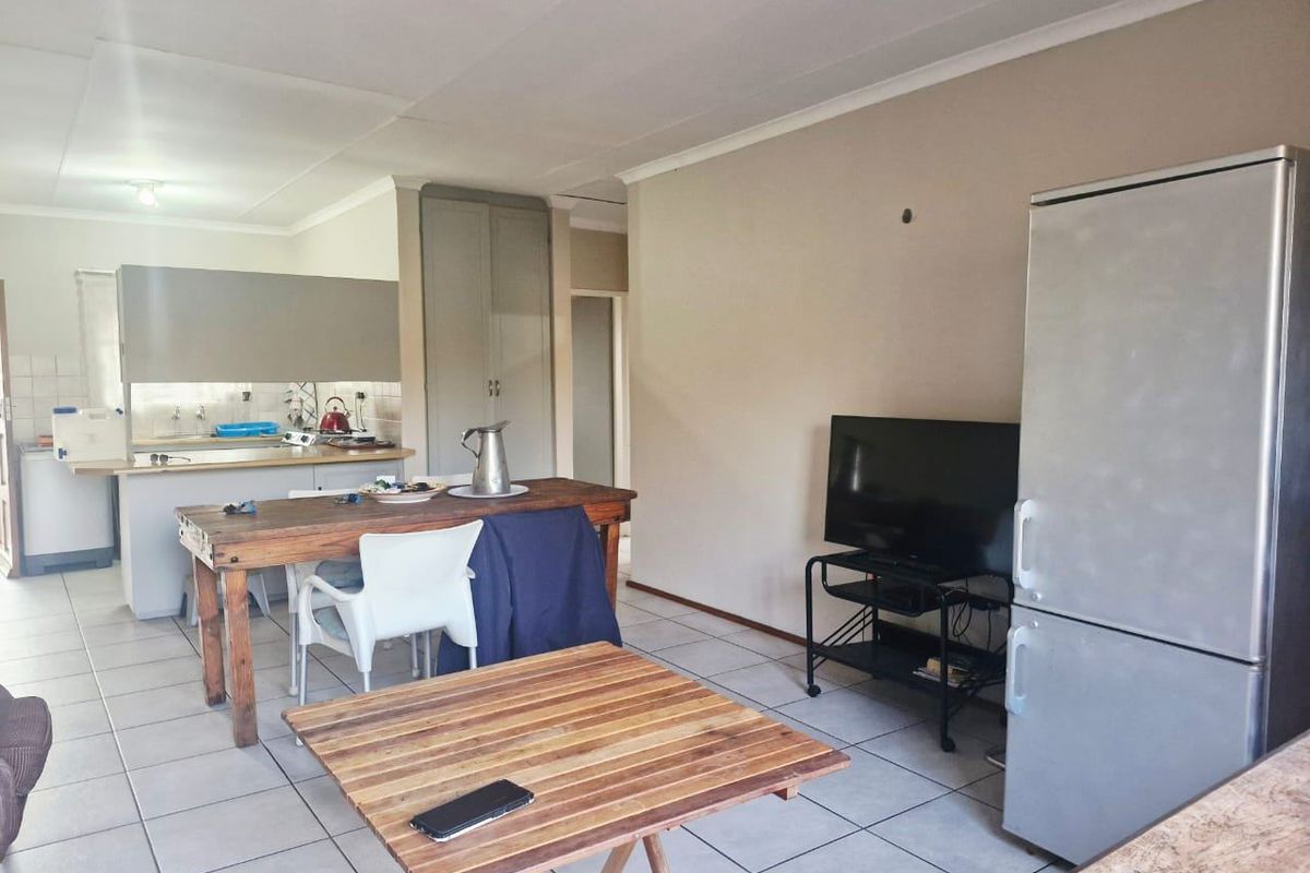 Open-plan living and kitchen area featuring tiled flooring, built-in cabinetry, and a functional layout suitable for modern living.