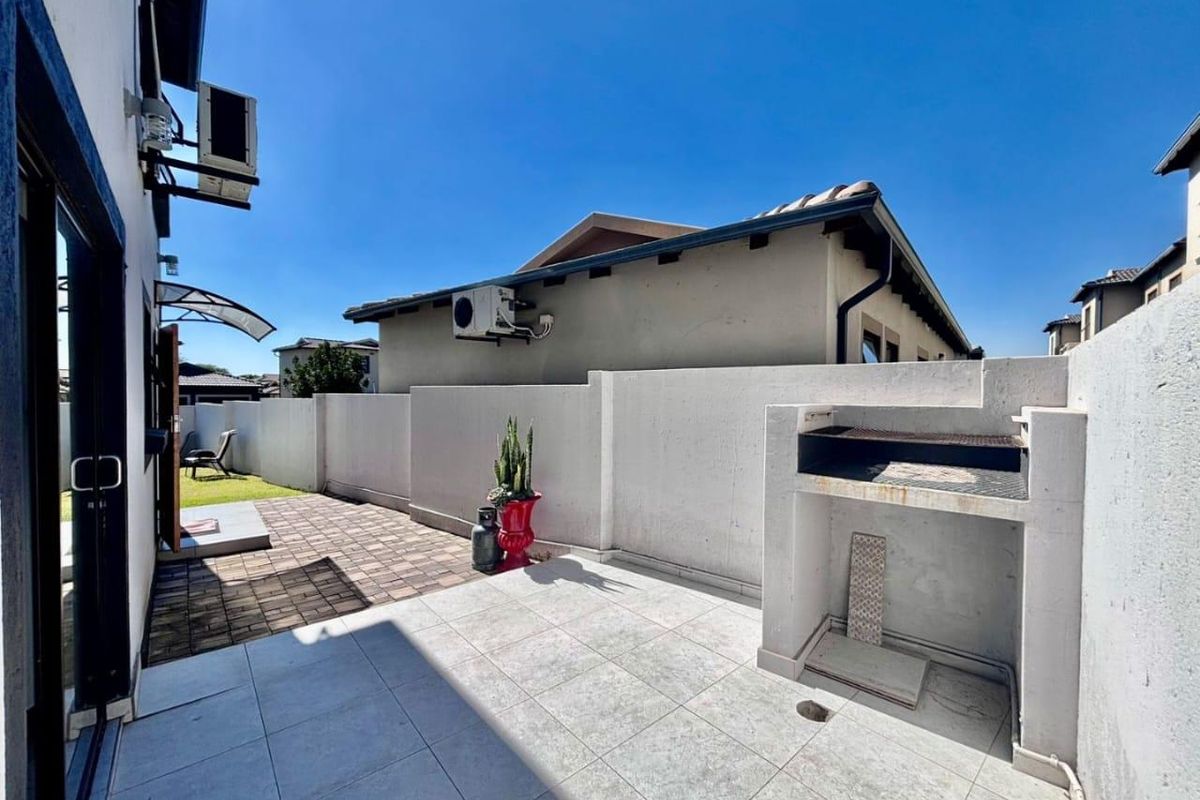 A private outdoor patio area featuring tiled flooring and a built-in braai, perfect for outdoor entertaining.