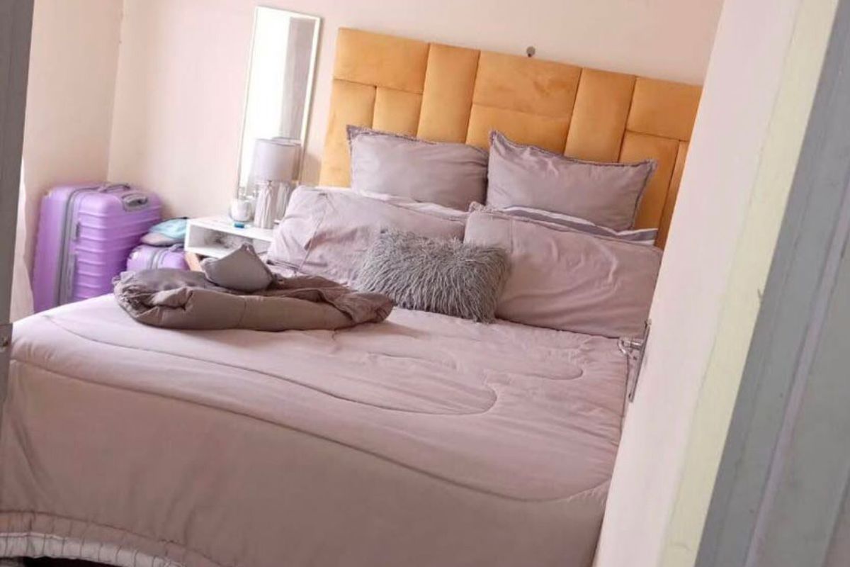 A bedroom featuring laminate flooring and coved ceiling details, viewed from the doorway.