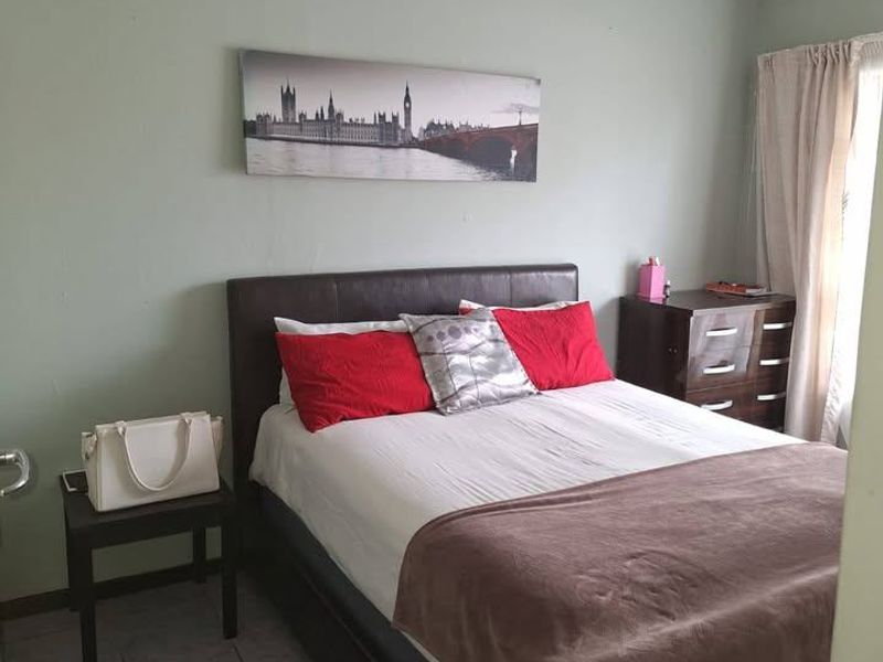 A standard bedroom featuring tiled flooring and a ceiling fan, providing a functional space for rest.