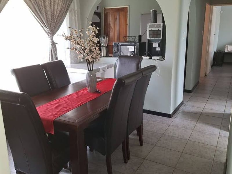 Dining area featuring tiled flooring and a distinctive arched opening leading to the kitchen space.