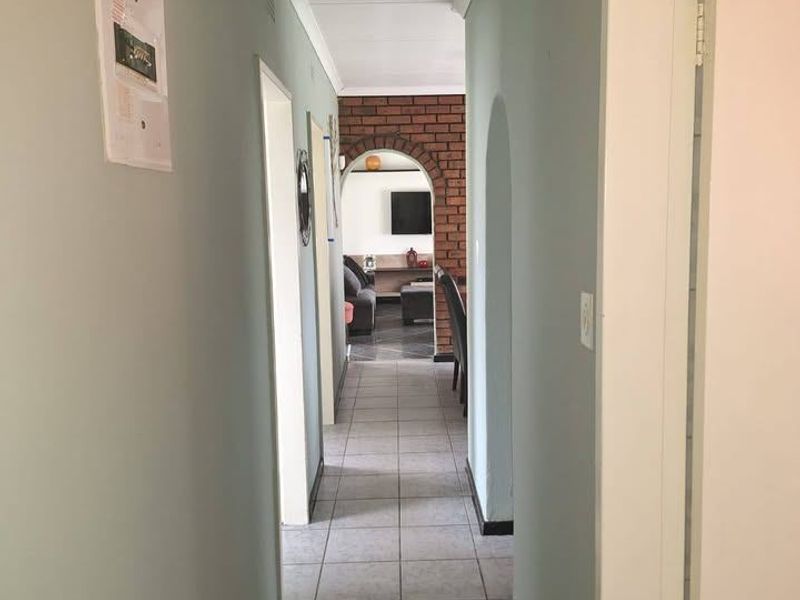 A central hallway featuring tiled flooring and an arched entryway leading into the living area.
