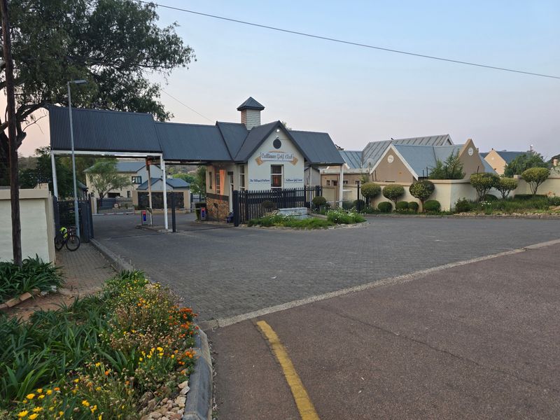 The secure entrance gatehouse of Cullinan Golf Estate, featuring paved access, established landscaping, and perimeter security fencing.