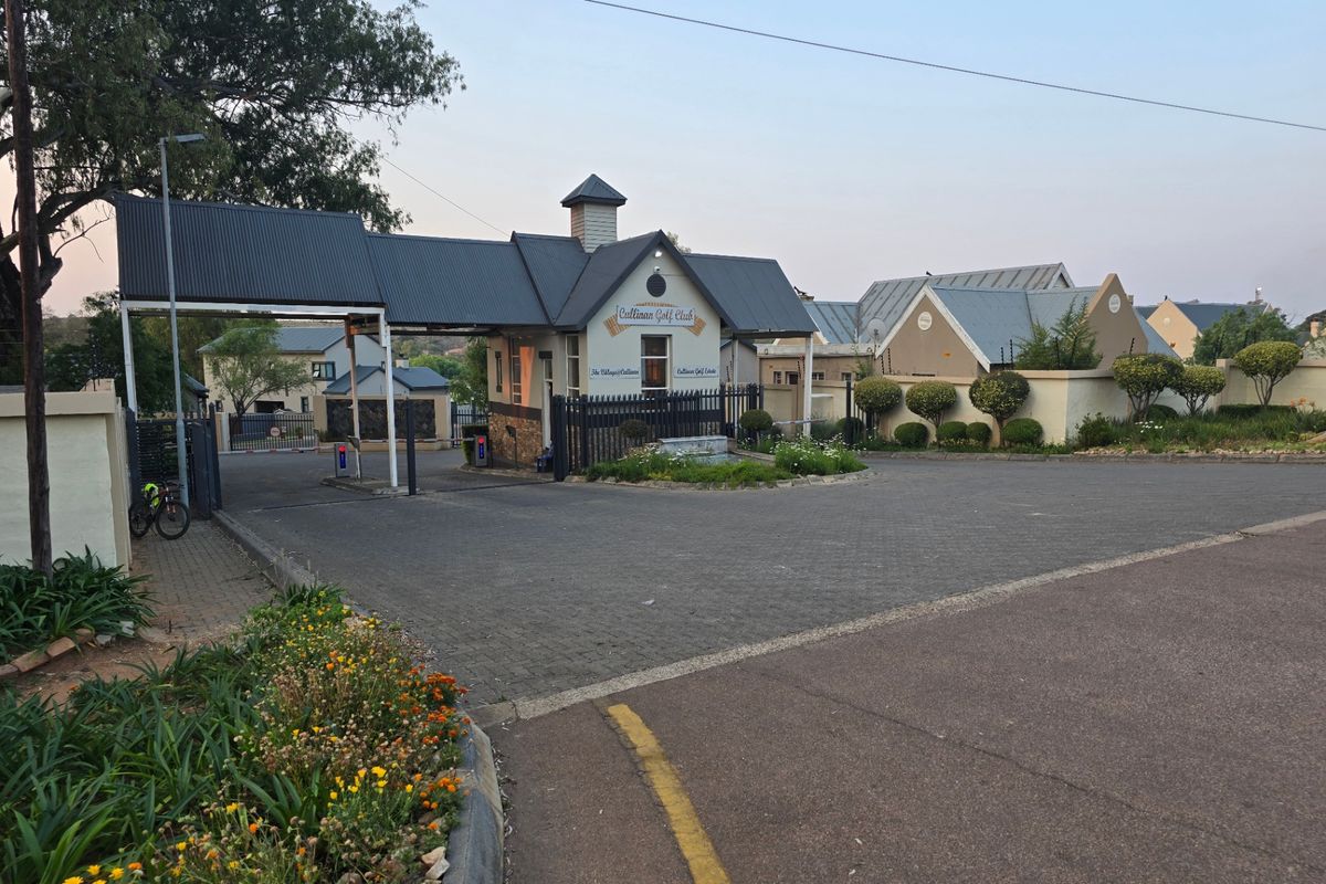 The secure entrance gatehouse of Cullinan Golf Estate, featuring paved access, established landscaping, and perimeter security fencing.