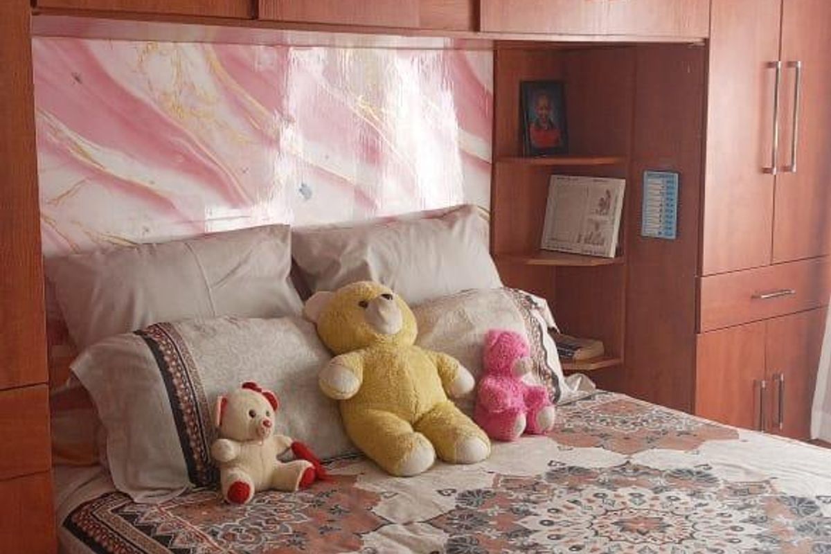 Bedroom featuring extensive built-in wooden cabinetry with integrated storage and a decorative headboard panel.