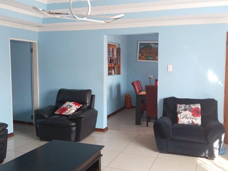 Open plan living and dining area featuring tiled flooring and coved ceilings, providing a functional layout for family living.