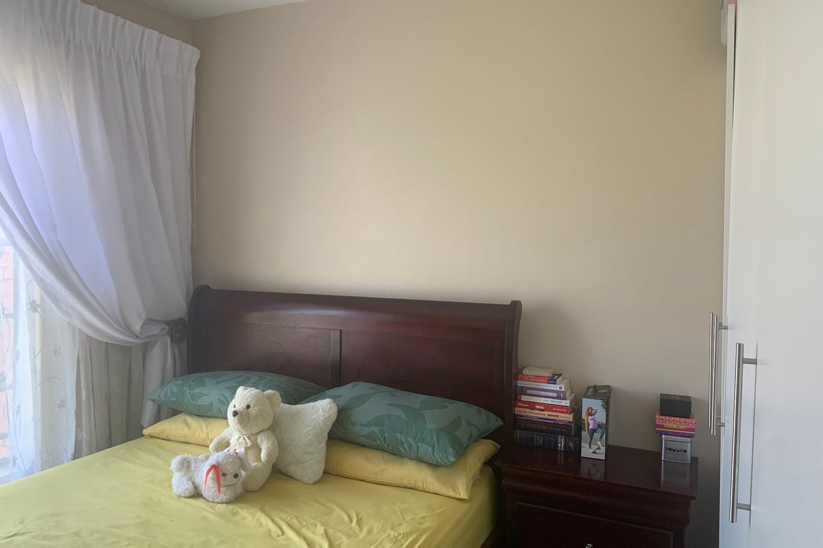 A bedroom featuring a built-in wardrobe and neutral wall finishes, providing a functional space for rest.
