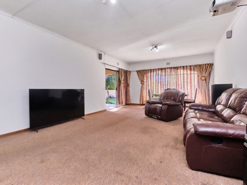 Spacious living room featuring neutral walls, carpeted flooring, and direct access to the outdoor patio area through sliding glass doors.