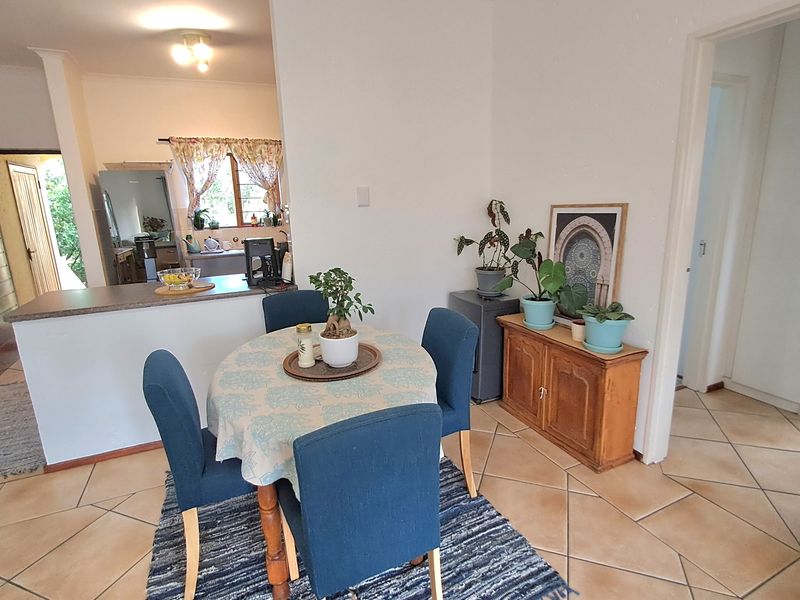 Open plan dining area featuring ceramic tile flooring and a breakfast bar connecting to the kitchen space.