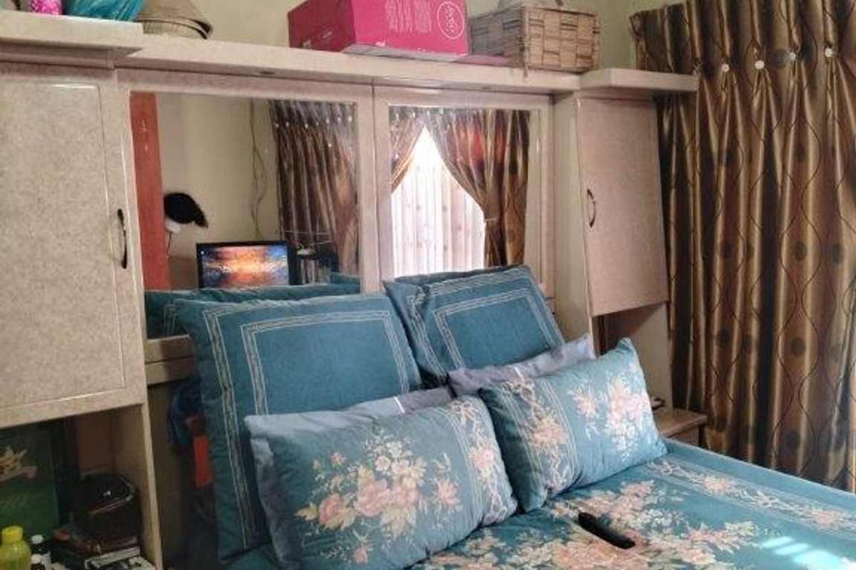 A bedroom featuring built-in cabinetry with integrated mirrored panels and decorative cove cornicing.