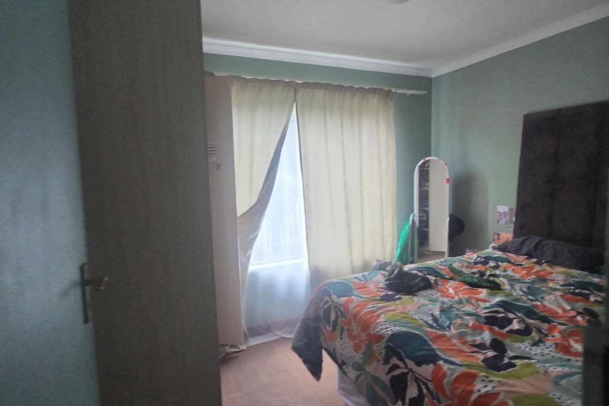 A standard bedroom featuring a built-in wardrobe, neutral wall finishes, and carpeted flooring, providing a functional and comfortable living space.