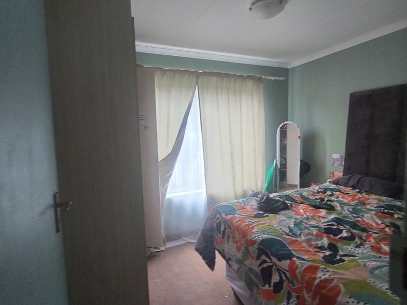A standard bedroom featuring a built-in wardrobe, neutral wall finishes, and carpeted flooring, providing a functional and comfortable living space.