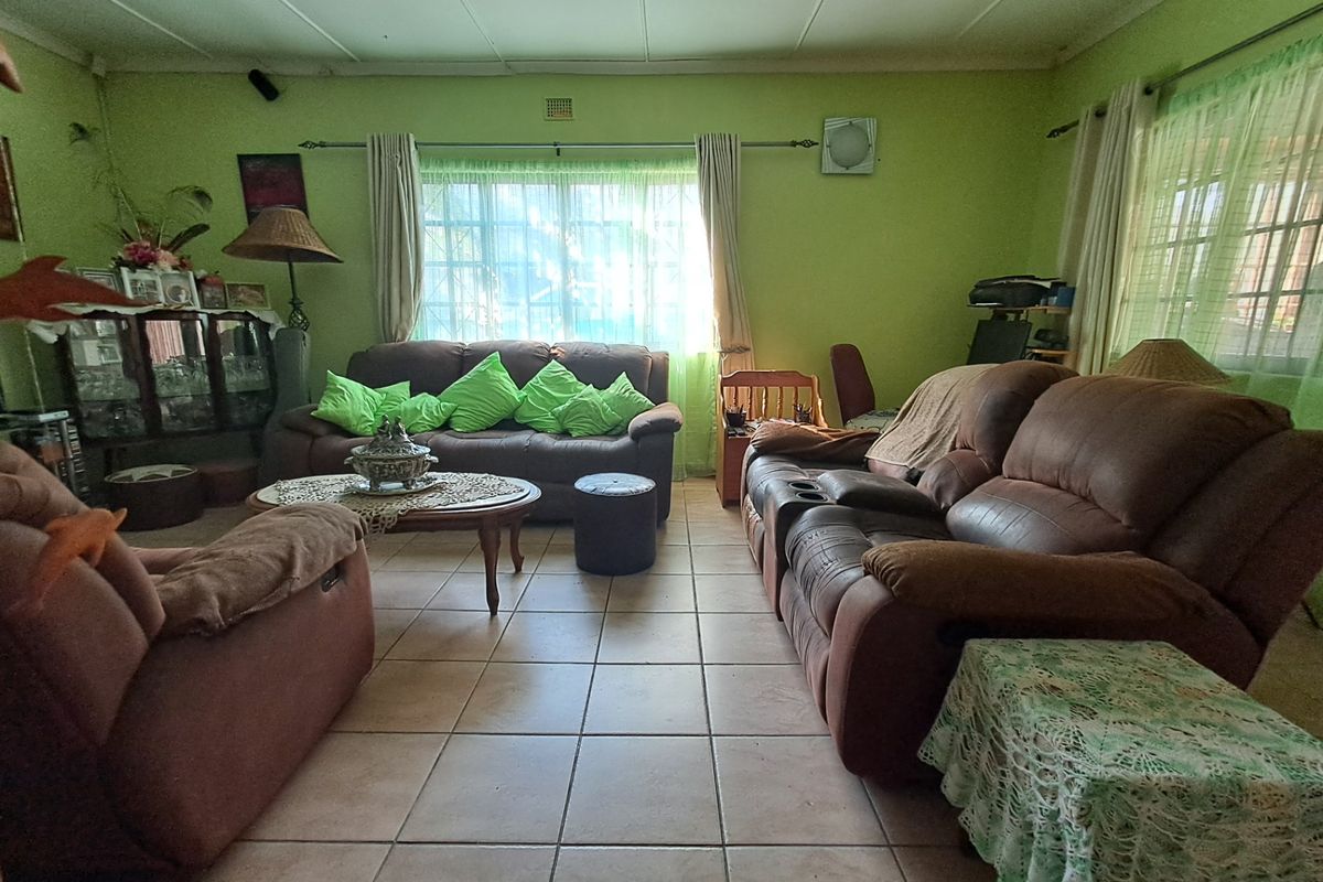 A spacious living room featuring ceramic floor tiles and a ceiling fan, offering a functional layout ready for modern updates and cosmetic improvements.