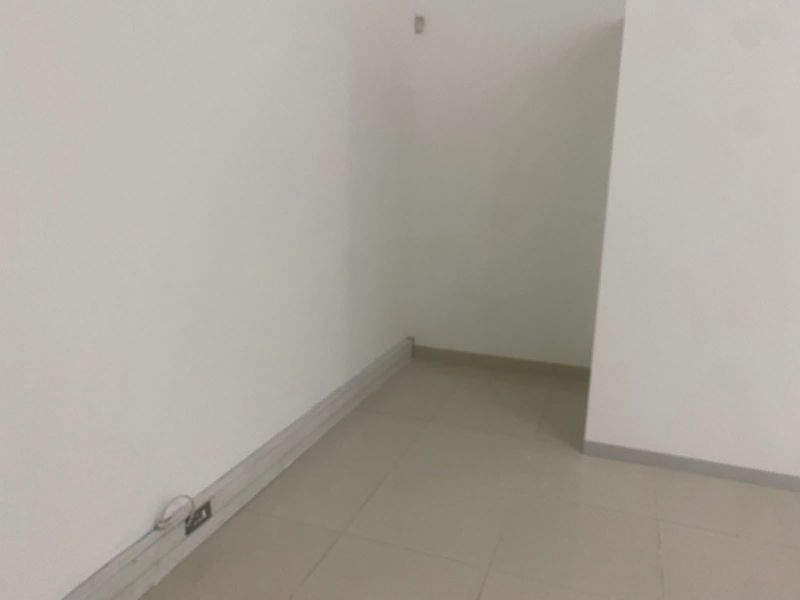 An empty, neutral-toned interior space featuring tiled flooring and basic electrical infrastructure, suitable for various commercial uses.
