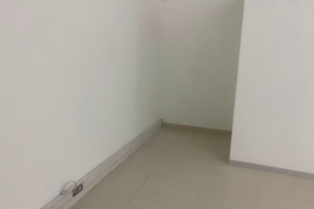 An empty, neutral-toned interior space featuring tiled flooring and basic electrical infrastructure, suitable for various commercial uses.