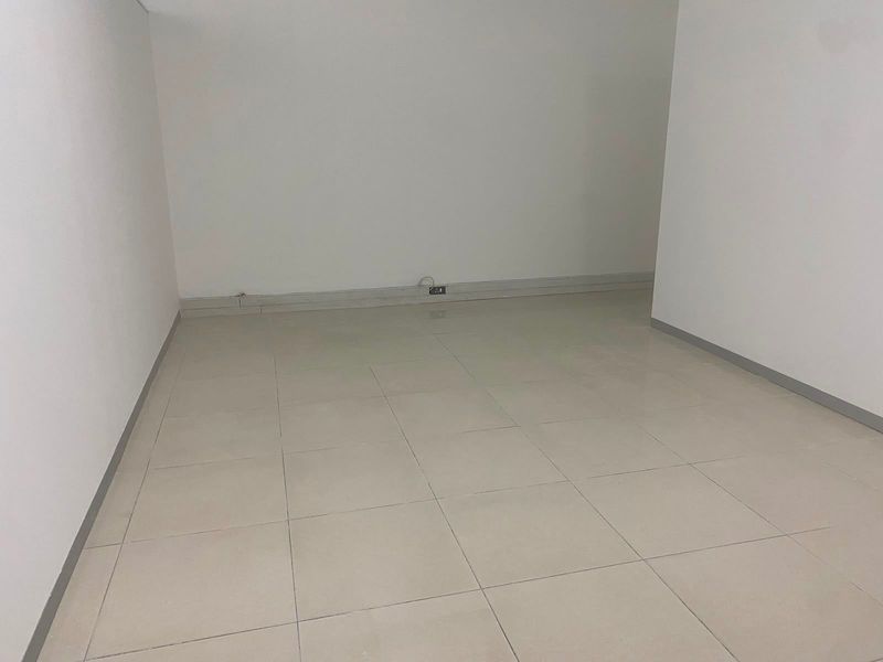 A clean, empty commercial office space featuring neutral tiled flooring and white walls, ready for custom fit-out or professional use.