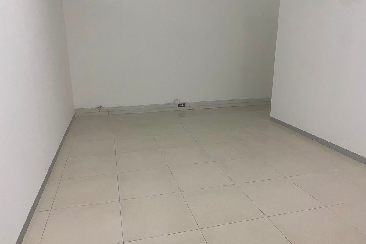 A clean, empty commercial office space featuring neutral tiled flooring and white walls, ready for custom fit-out or professional use.