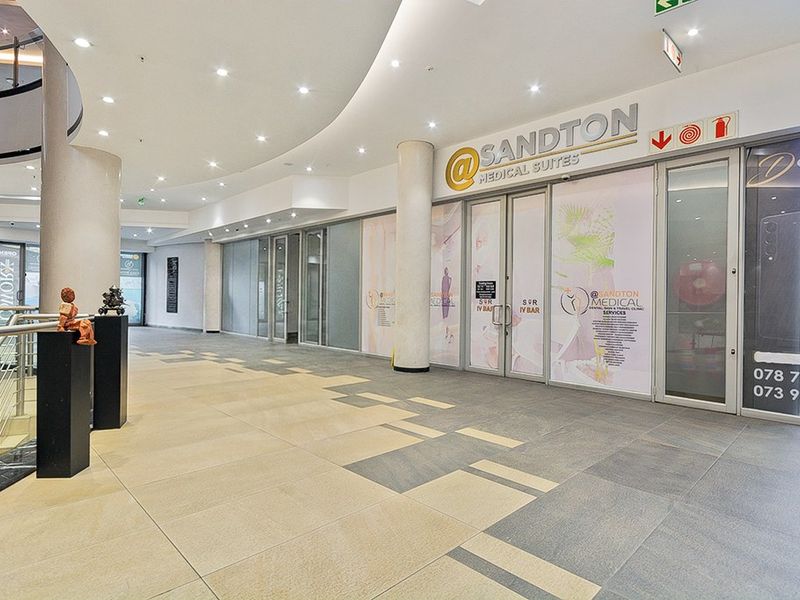 Modern commercial entrance featuring glass storefront, recessed lighting, and high-quality tiled flooring within a professional medical suite complex.