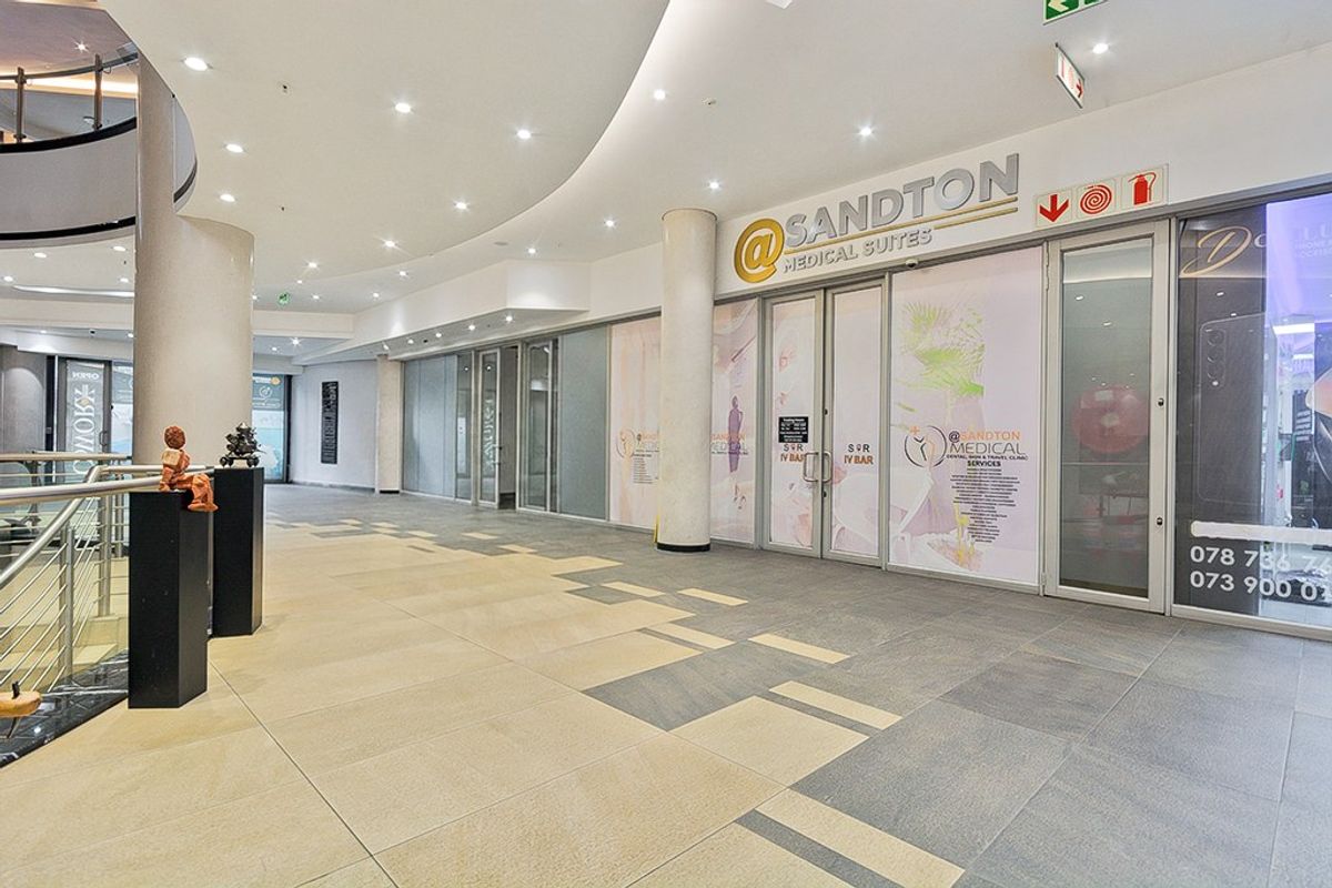 Modern commercial entrance featuring glass storefront, recessed lighting, and high-quality tiled flooring within a professional medical suite complex.