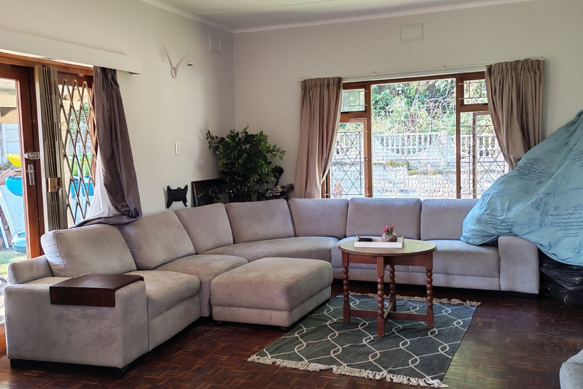 Spacious living room featuring classic parquet flooring, large windows for natural light, and direct access to the outdoor area through sliding doors.