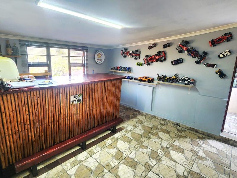 A dedicated bar area featuring a rustic built-in counter, tiled flooring, and direct access to an outdoor space.