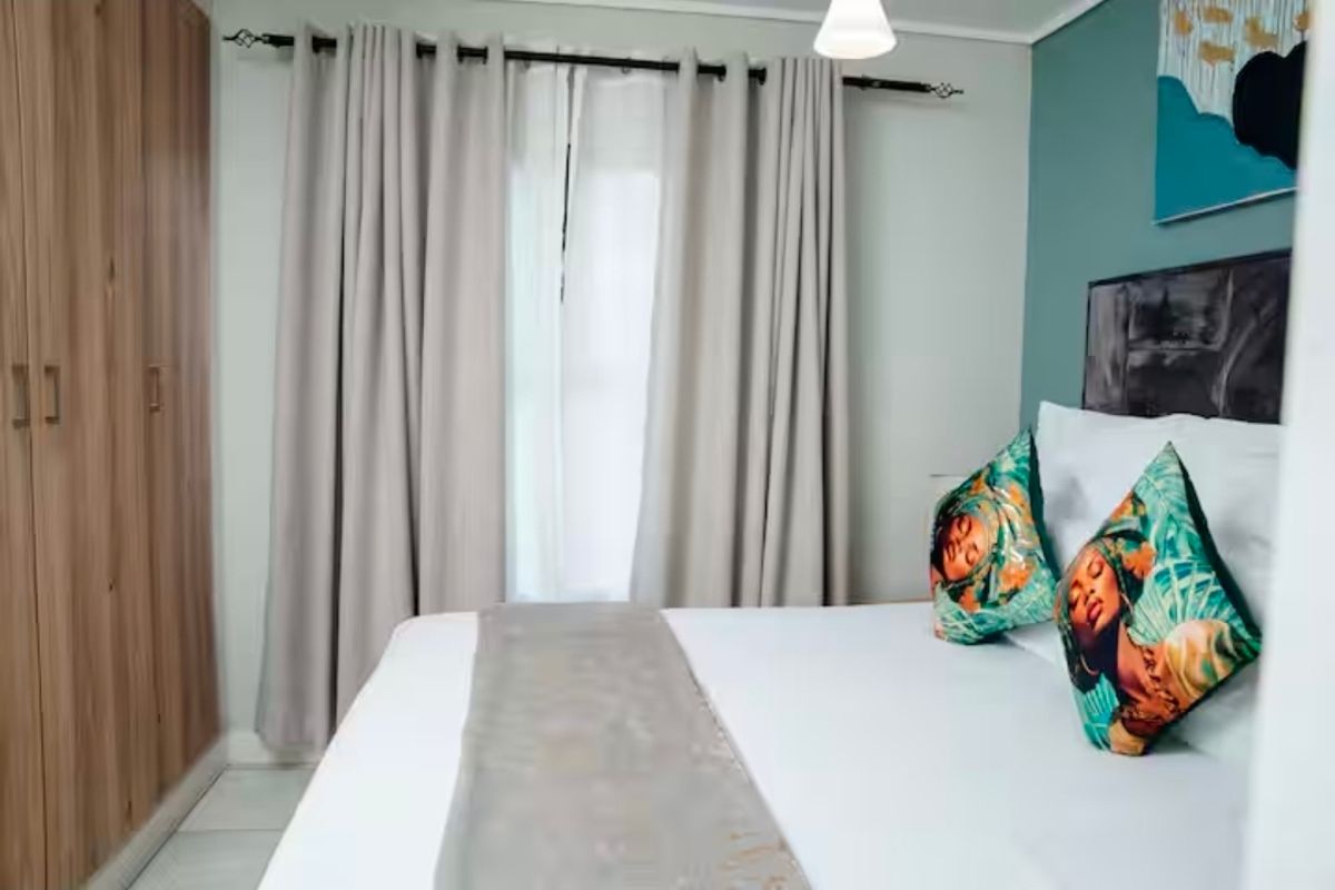 A well-maintained bedroom featuring built-in wooden wardrobes and neutral tiled flooring, offering a clean and functional living space.