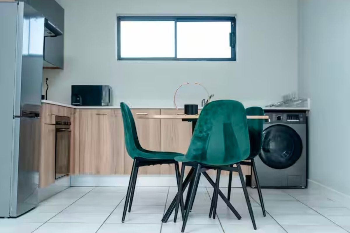 Modern kitchen featuring light wood-finish cabinetry, tiled flooring, built-in oven, and integrated appliance space, offering a clean and functional culinary area.