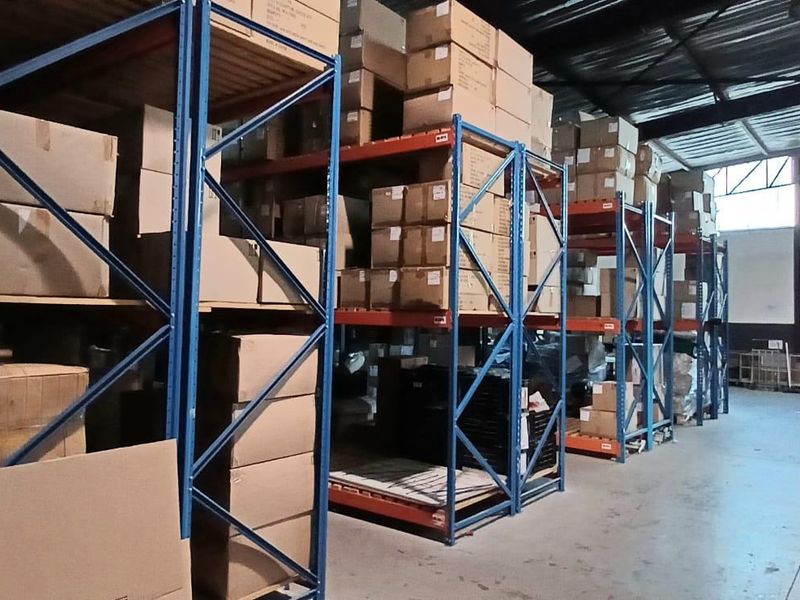 Spacious industrial warehouse facility featuring high-clearance ceilings, durable concrete flooring, and extensive built-in steel racking systems for efficient storage and logistics operations.