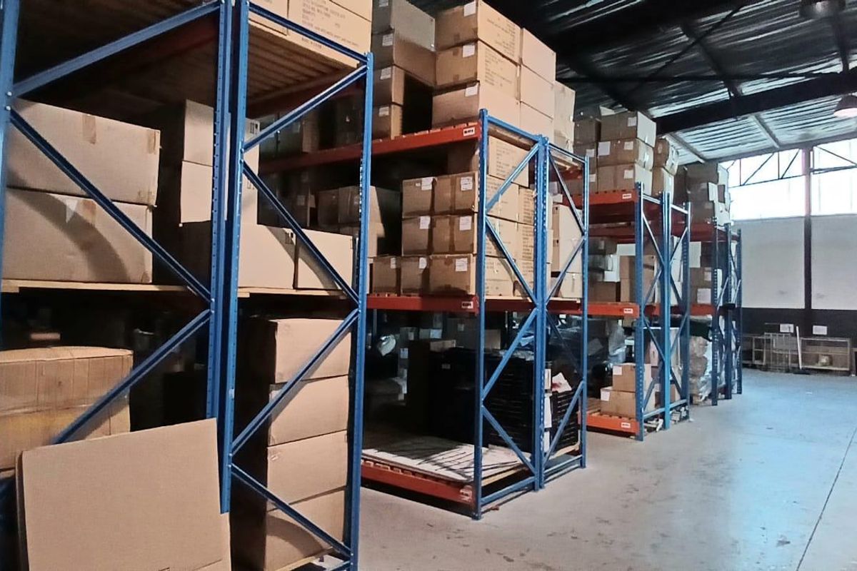 Spacious industrial warehouse facility featuring high-clearance ceilings, durable concrete flooring, and extensive built-in steel racking systems for efficient storage and logistics operations.