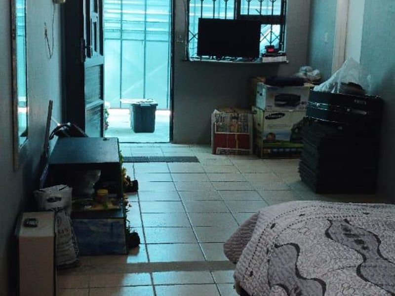 A bedroom featuring tiled flooring, security bars on the window, and direct access to an exterior area.