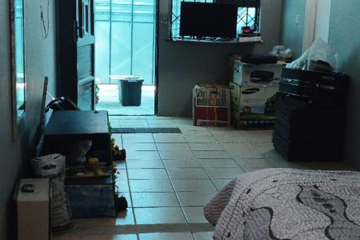 A bedroom featuring tiled flooring, security bars on the window, and direct access to an exterior area.