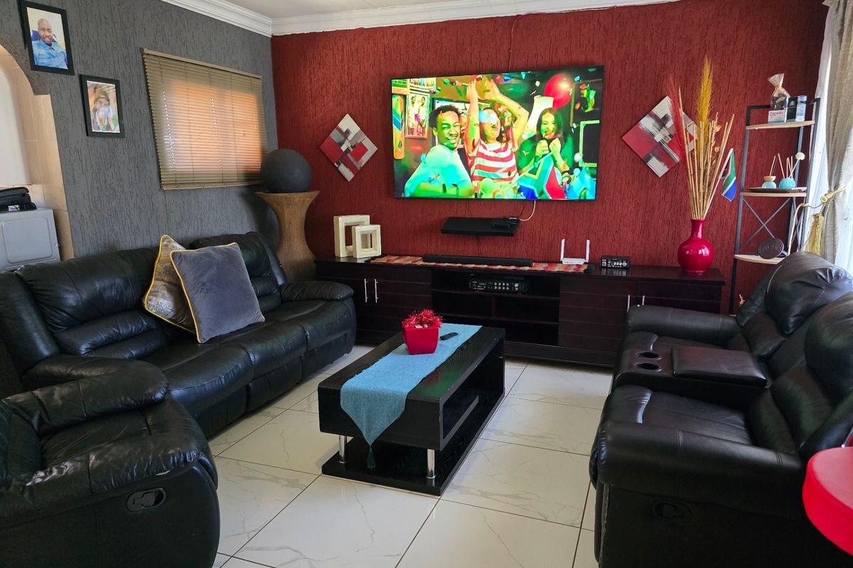 A comfortable living room featuring large format floor tiles and a bold red textured feature wall.