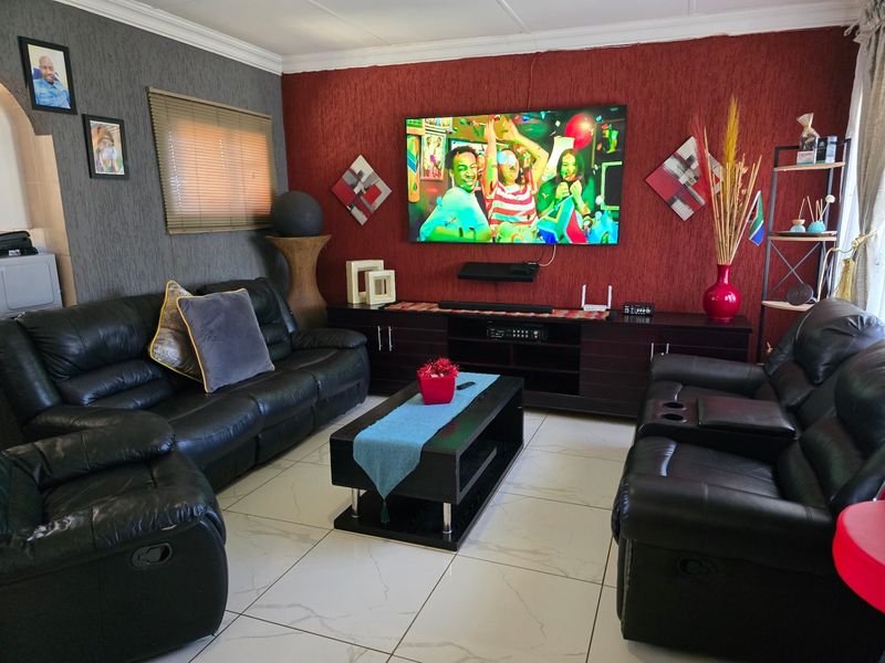A comfortable living room featuring large format floor tiles and a bold red textured feature wall.