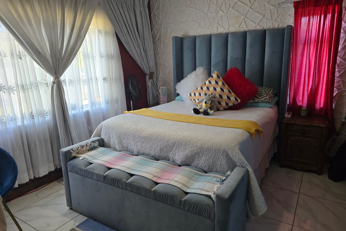 A well-maintained bedroom featuring a textured accent wall and tiled flooring, providing a comfortable and functional living space.