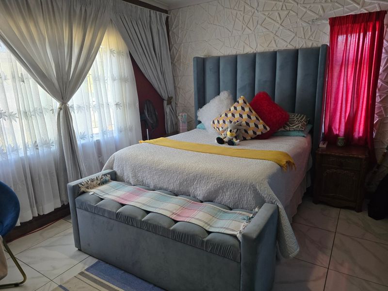A well-maintained bedroom featuring a textured accent wall and tiled flooring, providing a comfortable and functional living space.
