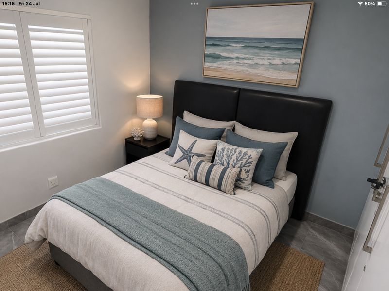 A well-maintained bedroom featuring tiled flooring, plantation shutters, and a neutral color palette with a feature wall.