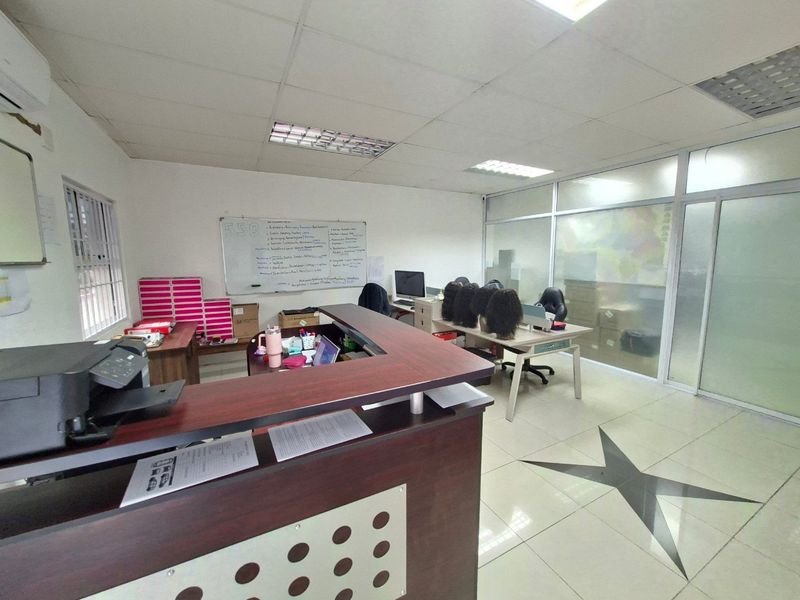 Commercial office space featuring a reception desk, glass partition wall, suspended ceiling, and tiled flooring.