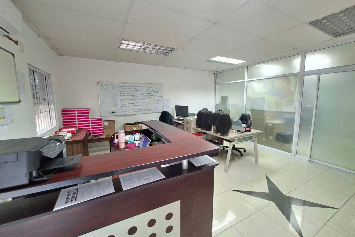 Commercial office space featuring a reception desk, glass partition wall, suspended ceiling, and tiled flooring.