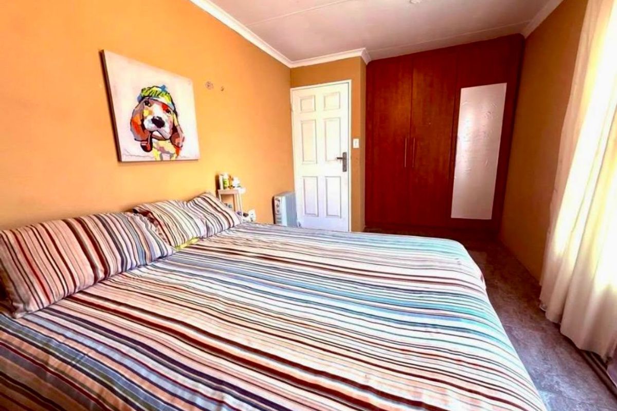A bedroom featuring built-in wooden wardrobes, a panel door, and coved ceiling details.