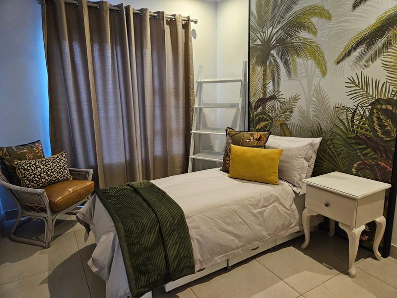 A well-maintained bedroom featuring tiled flooring and neutral wall finishes, providing a comfortable and functional living space.