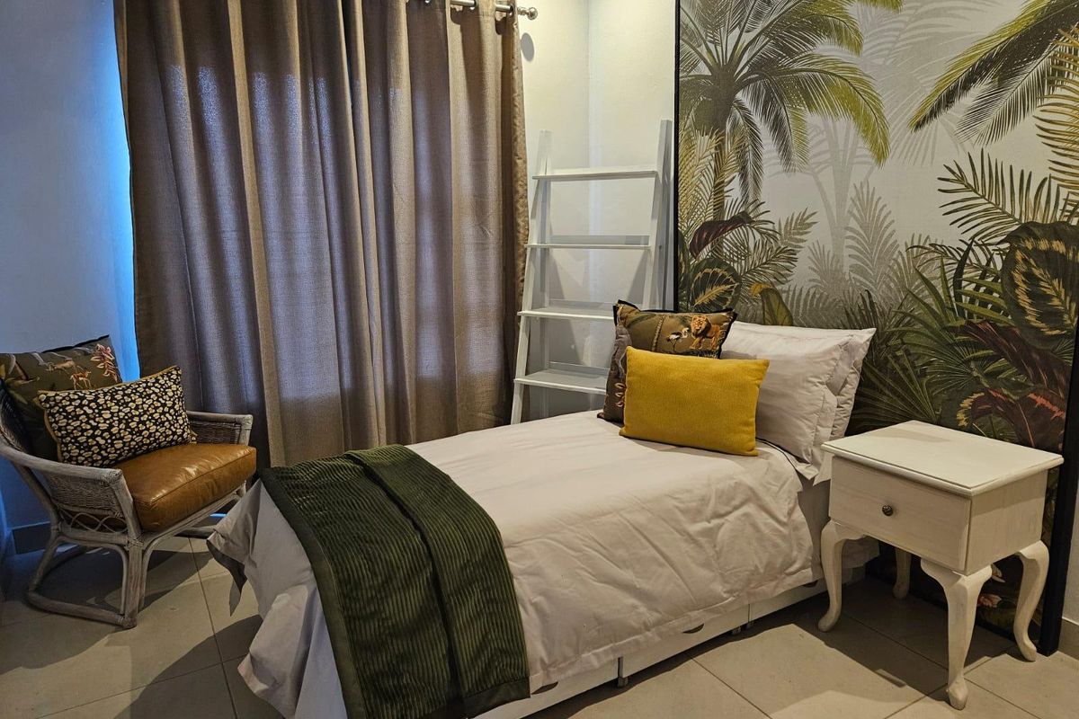 A well-maintained bedroom featuring tiled flooring and neutral wall finishes, providing a comfortable and functional living space.