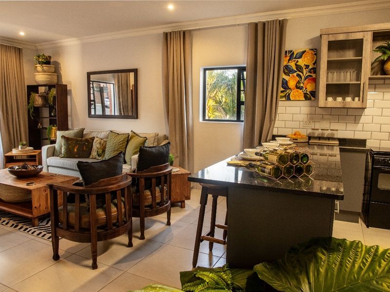 Modern open-plan living area featuring a well-appointed kitchen with granite countertops, subway tile backsplash, and seamless flow into the comfortable lounge space.