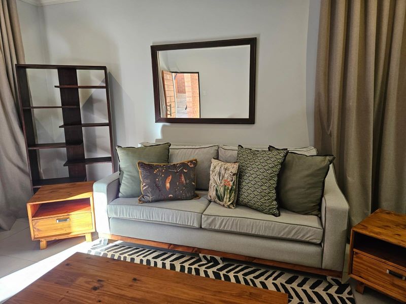 A comfortable living room area featuring neutral wall tones and tiled flooring, providing a functional and inviting space for relaxation.