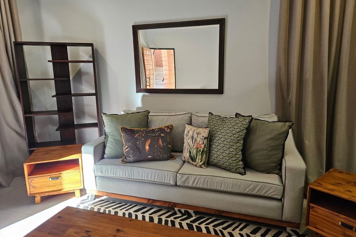 A comfortable living room area featuring neutral wall tones and tiled flooring, providing a functional and inviting space for relaxation.