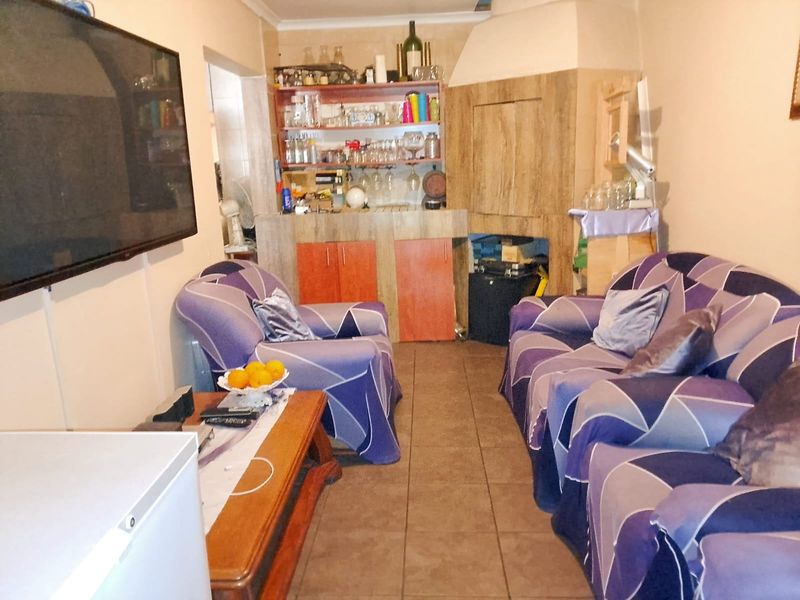 Living room featuring tiled flooring, a built-in bar area, and a built-in fireplace.