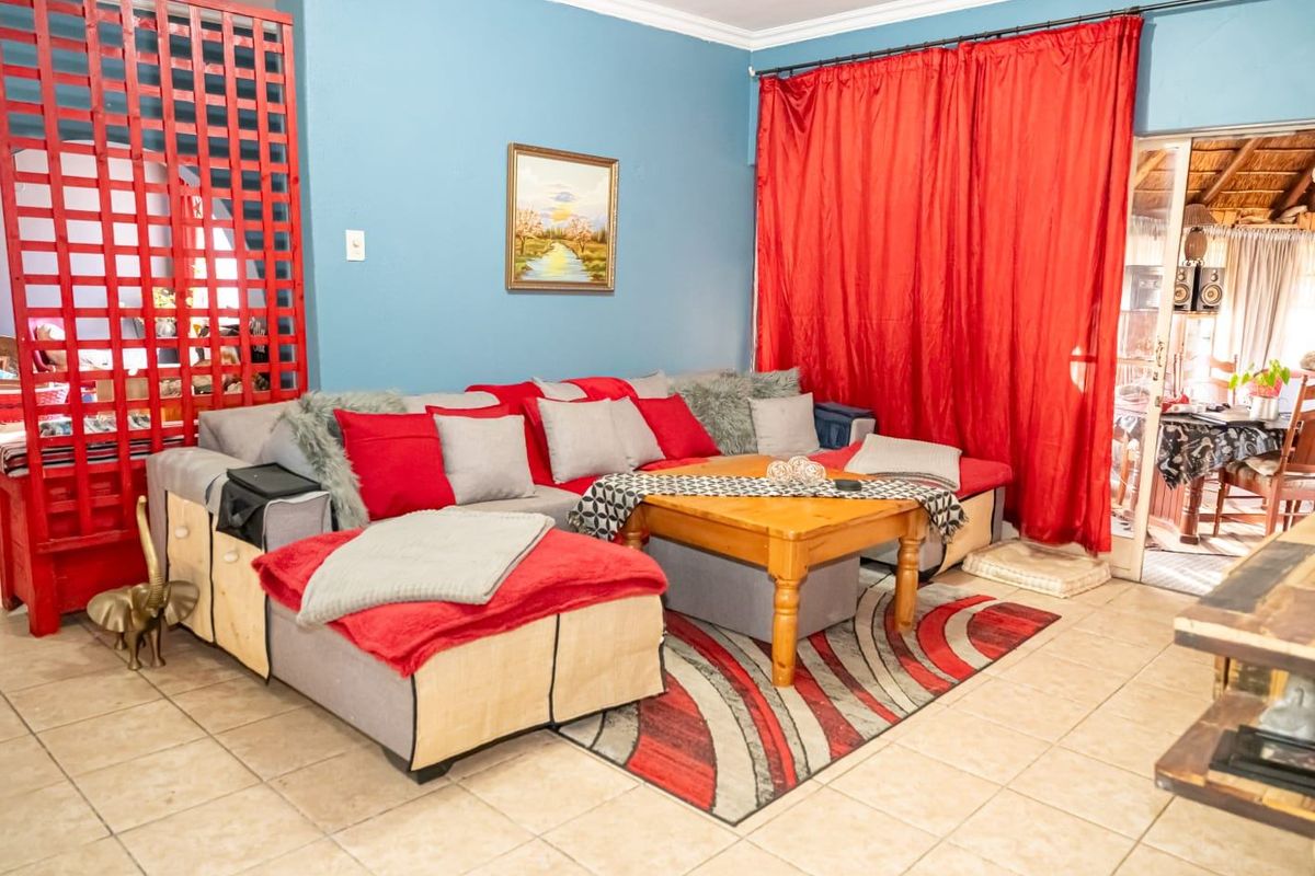 A living room area featuring tiled flooring and access to an adjoining patio space through a sliding door.