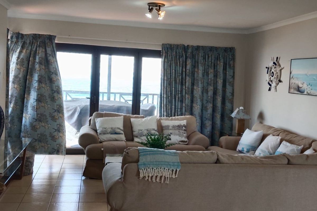 A comfortable living room featuring tiled flooring and large sliding glass doors that provide natural light and access to the outdoor area.