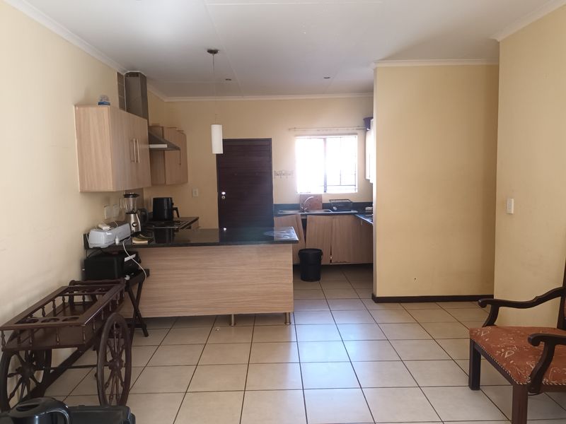 Functional kitchen featuring light wood cabinetry, granite countertops, a breakfast bar, and tiled flooring, offering a practical layout for daily meal preparation.