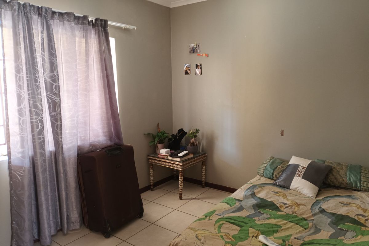 A standard bedroom featuring tiled flooring and neutral wall tones, offering a functional space ready for personalization.
