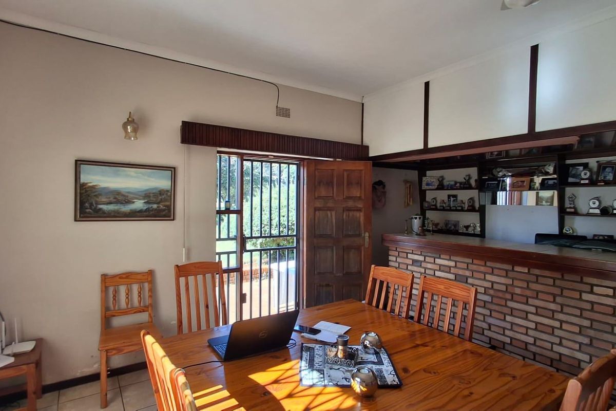 Living area featuring a built-in brick bar, tiled flooring, and direct access to the exterior through a security gate.